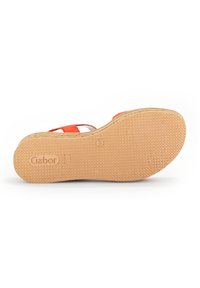 Orange sandal med en tekstureret gummisål. Har et åbent design, hvide accenter og et mærke-logo på indersålen.