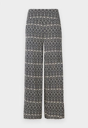 Hlače širokih nogavic s črno-belim geometrijskim vzorcem, izdelane iz tkanine z gladko teksturo. Elastičen pas za udobje.