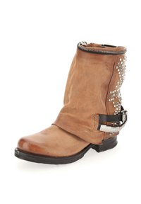 Botte cheville en cuir marron avec un bout arrondi, fermeture éclair, clous en argent décoratifs sur le côté, et une sangle noire autour de la cheville.