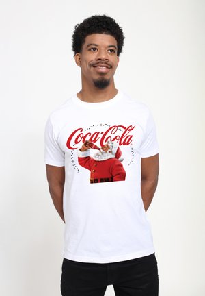 Weißes Baumwoll-T-Shirt mit einem Grafikmotiv von Santa Claus in einem roten Anzug, der aus einer Coca-Cola-Flasche trinkt, mit rotem Schriftzug und Sternen.