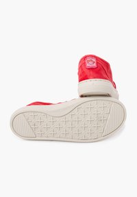 Rode canvas hoge sneakers met een witte rubberen zool, voorzien van een ronde logopatch aan de achterkant en een gestructureerd loopvlakpatroon op de zool.