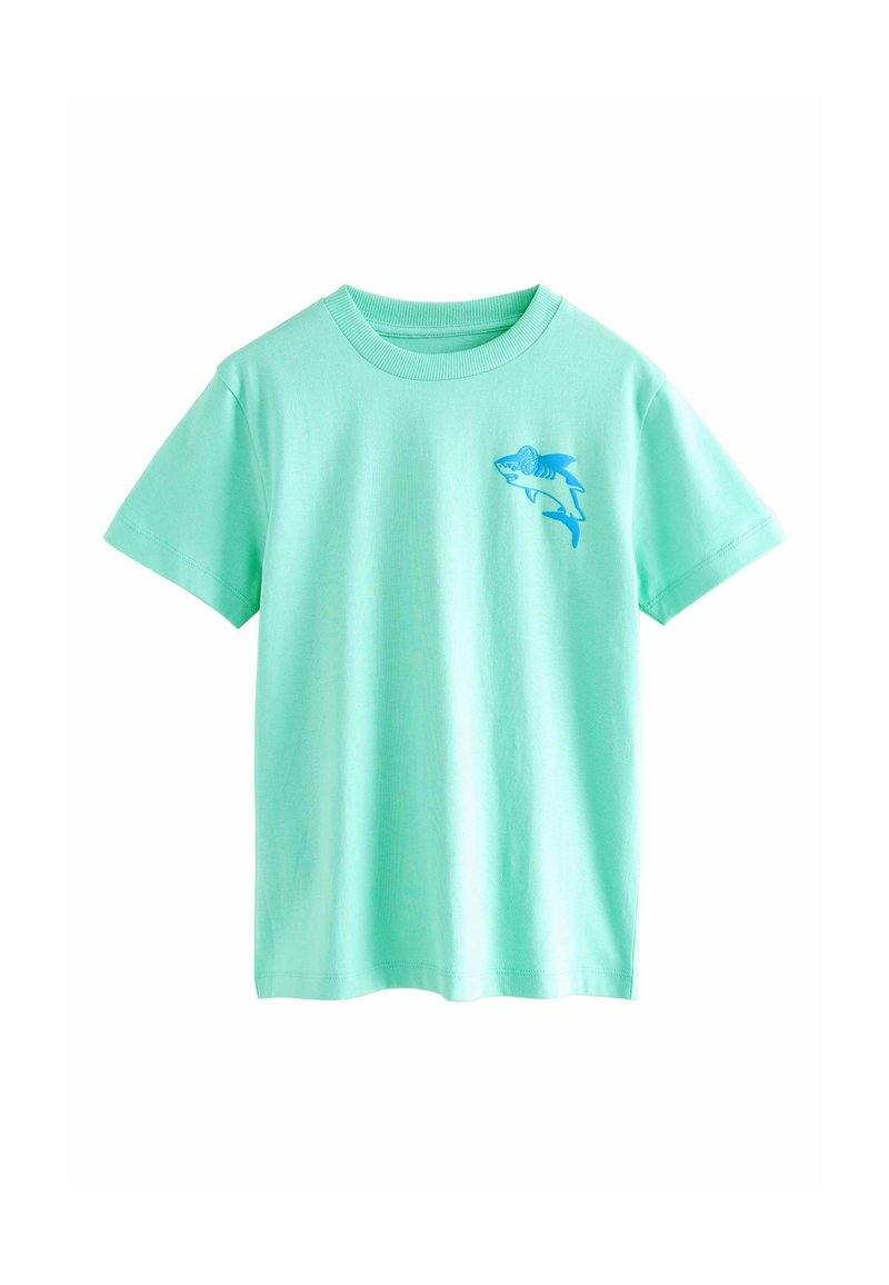Mintgrünes Baumwoll-T-Shirt mit kurzen Ärmeln und Rundhalsausschnitt. Mit einem blauen Haifisch-Design auf der linken Brust. Weicher Stoff, lockere Passform.