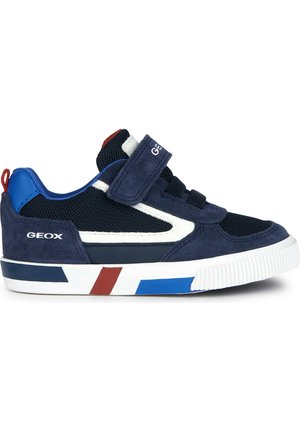 Sneaker bleu marine avec tige en mesh et daim, accents blancs, rayures rouge et bleue sur la semelle, et sangle en Velcro pour un ajustement sécurisé.