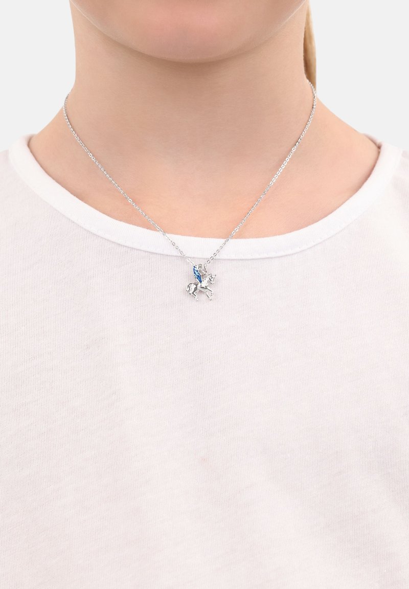 Collana d'argento con una figura montata su un cavallo, con un accento blu. La catena ha un design delicato, indossata sopra una camicia bianca.