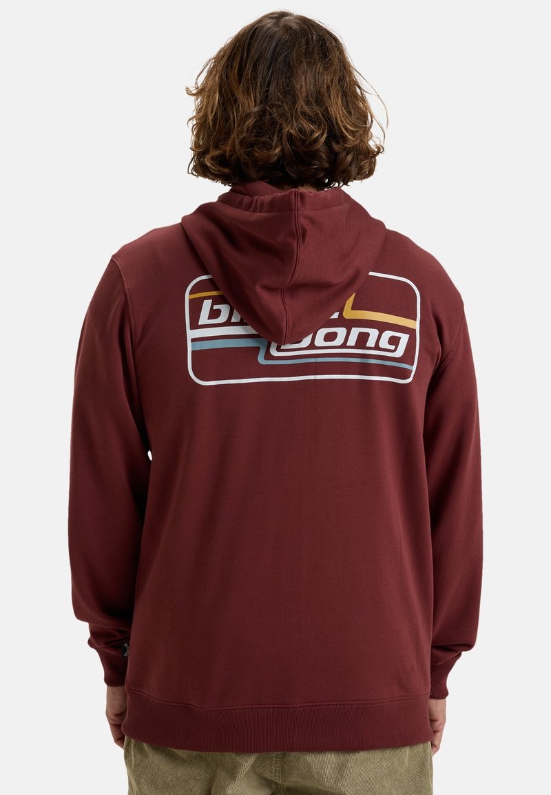 Sudadera color burdeos con un bolsillo canguro, que presenta un gran logo en la parte posterior. Fabricada con una tela suave y con un corte relajado. Puños y dobladillo texturizados.