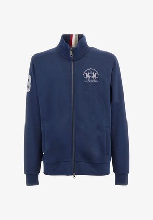 Sudadera de navy con cremallera, fabricada en un tejido suave, con un cuello alto, bolsillos laterales, logo bordado y el número 3 en blanco en la manga.