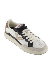 Zapatilla blanca y beige con un diseño negro, acentos de estampado de leopardo, punta perforada y suela de goma texturizada. Presenta un cierre de cordones.