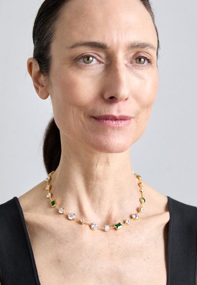 Colier din aur cu un model alternativ de pietre prețioase clare și verzi, cu forme variate, inclusiv rotunde, pătrate și dreptunghiulare.