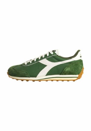 Scarpa da ginnastica bassa verde e bianca con lacci bianchi, punta e tallone in suede e suola in gomma color gomma con tacchetti antiscivolo.
