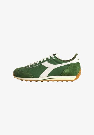 Scarpa da ginnastica bassa verde e bianca con lacci bianchi, punta e tallone in suede e suola in gomma color gomma con tacchetti antiscivolo.