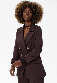 Dubbelzijdig jasje in donkerbruin stof, met gouden ronde knopen, een ontspannen fit en gestructureerde revers met een zachte textuur.