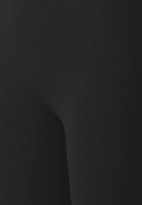 Leggings neri realizzati in un tessuto liscio e elastico, caratterizzati da un design aderente e dettagli di cucitura minimi, per un aspetto slanciato.