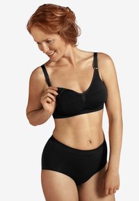 Svart amningsbh med justerbara remmar och mjukt tyg, matchad med svarta högmidjade trosor, slät textur.