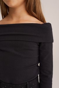 Fekete bordázott, off-shoulder hosszú ujjú felső, testhezálló fazonnal. Simaszövet, vízszintes bordákkal és széles nyakkivágással.