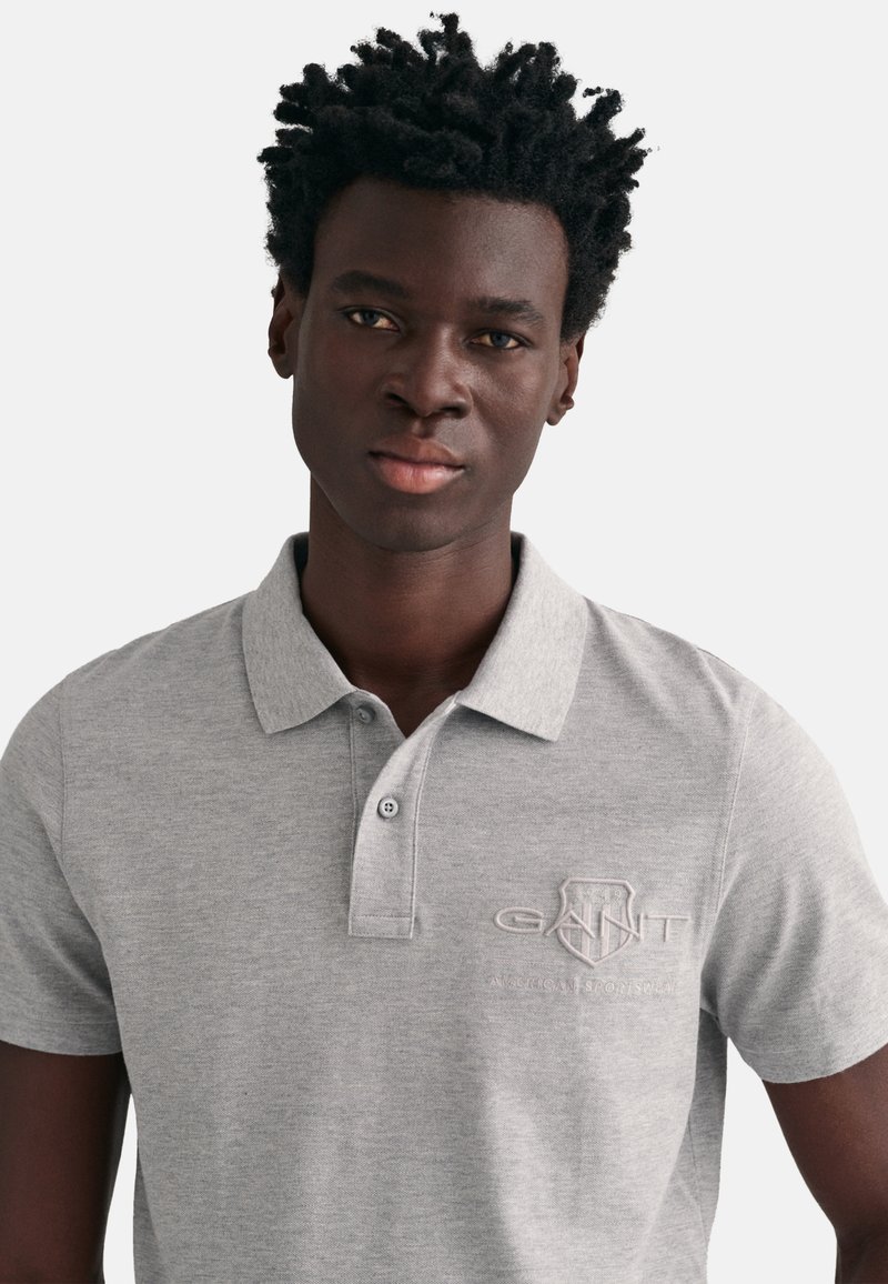 Szara koszulka polo wykonana z mieszanki bawełny, z zapięciem na guziki, haftowanym logo w odcieniu tonalnym, krótkimi rękawami i klasycznym kołnierzykiem.