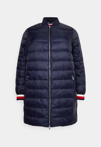 Námořnická péřová bunda s stojáčkem, předním zipem a žebrovanými manžetami s červenými a bílými akcenty. Lehký, prošívaný design s bočními kapsami.