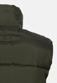 Dunkelgrüne gepolsterte Weste mit hohem Kragen, glatter Textur und gestickten Details. Verfügt über ein kleines Etikett im Nackenbereich.