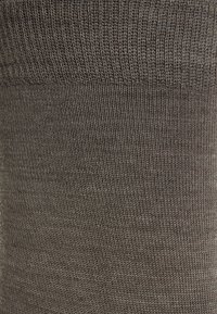 Dark grey socks with a fine ribbed texture, featuring a narrow cuff at the top, made from a stretchy material for comfort.