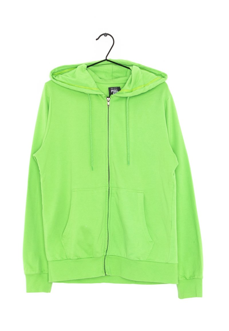 Sweat à capuche zippé vert vif avec poches avant, cordons et capuche, suspendu sur un cintre noir sur fond blanc.