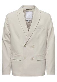 Blazer de doble botonadura en beige claro, confeccionado en una tela suave. Presenta dos bolsillos delanteros y seis botones, con un diseño de cuello con muesca.