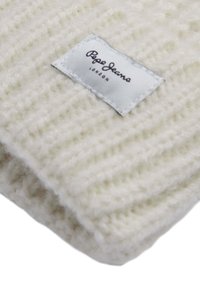 Gorro de punto blanco con un patrón texturizado y una etiqueta cosida que presenta "Pepe Jeans London." El material parece suave y cálido.