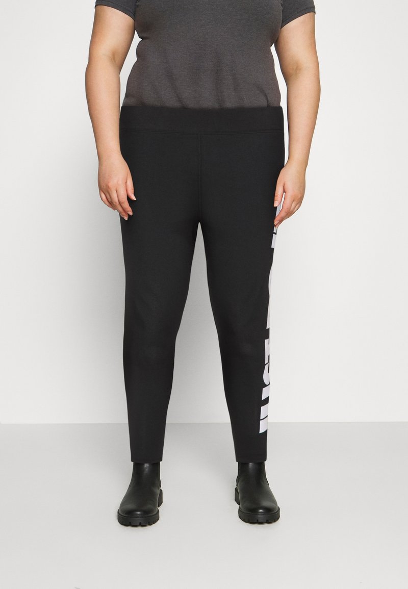 Svarta leggings med hög midja, med en vit logotypdetalj på vänster sida, tillverkade av stretchigt material för komfort.