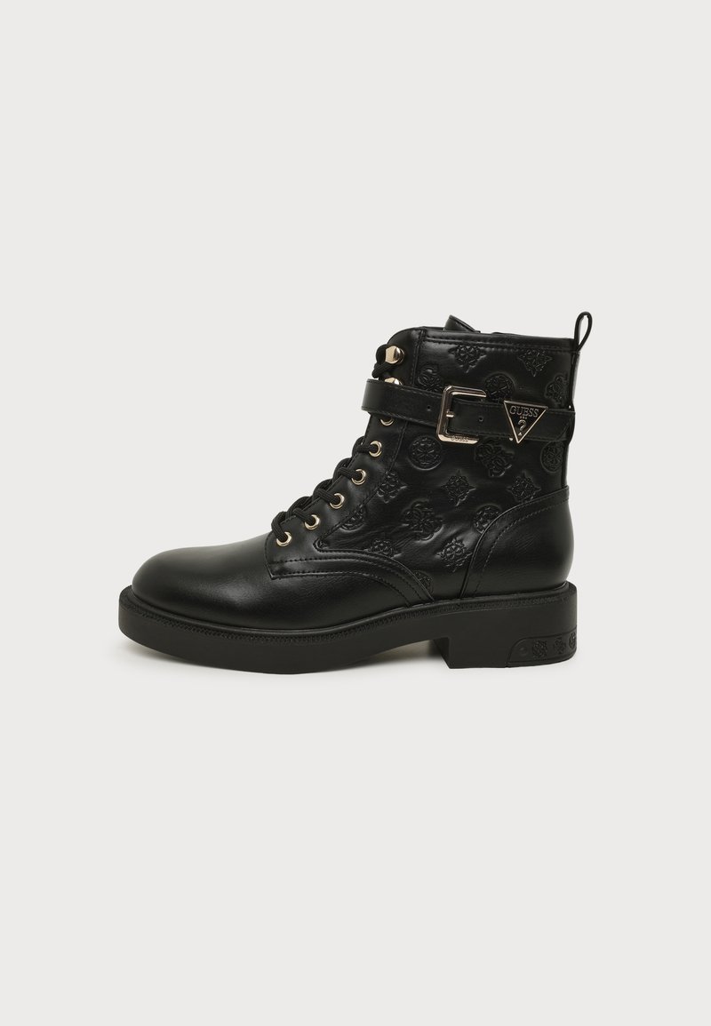 Bottine en cuir noir avec motifs floraux embossés, lacets à l'avant et bride à la cheville avec boucle métallique au logo Guess.