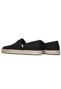 Zwarte canvas espadrilles met een jute touw zool, slip-on ontwerp en zonder zichtbare hardware. Aan beide zijden is een klein merklabel aangebracht.
