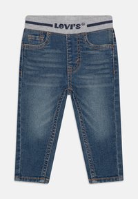 Denimjeans i ljusblå tvätt, med fem fickor, kontrasterande sömmar och en grå elastisk midja med marinblå detaljer.