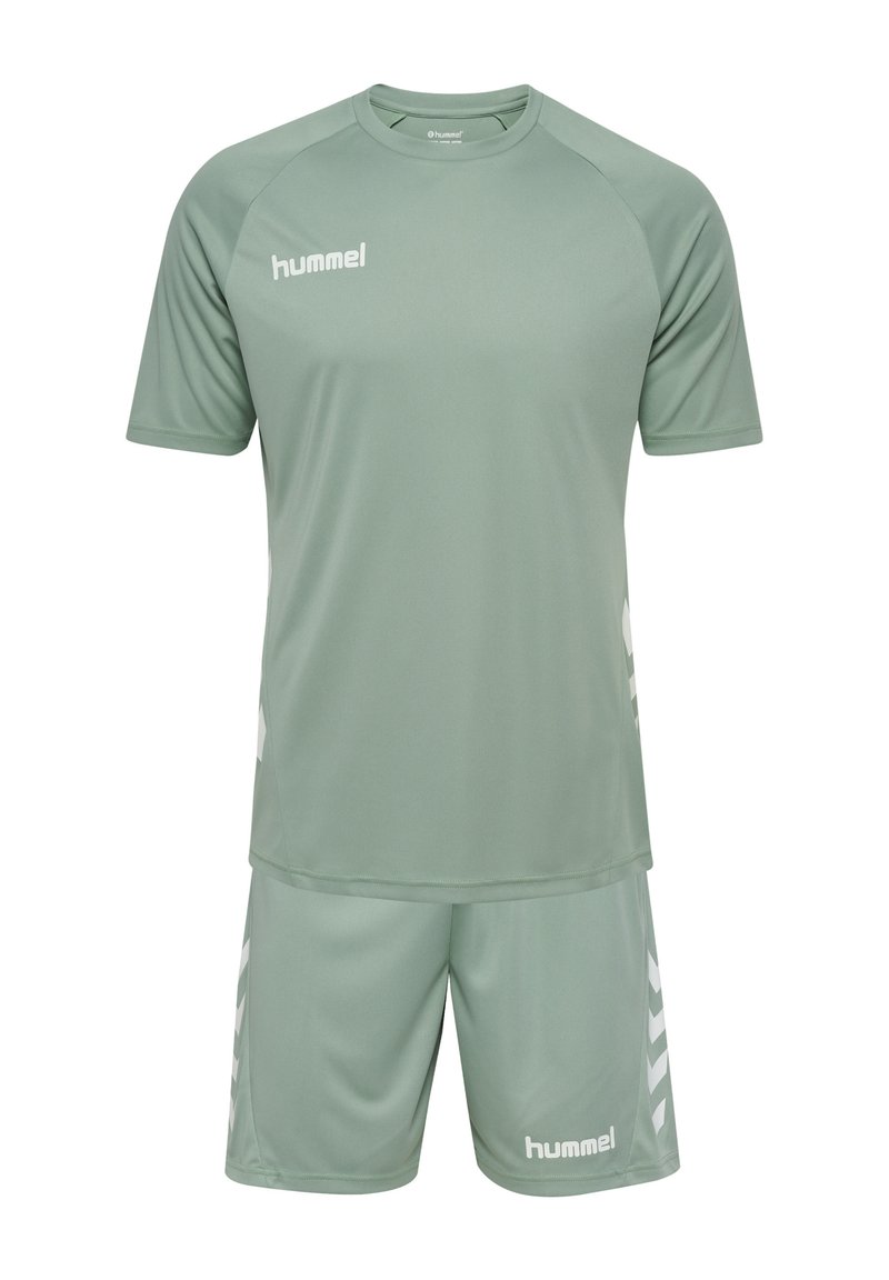 Ljust grönt sportställ bestående av en kortärmad tröja och shorts, med vita logotyper och chevronmönster på sidorna.