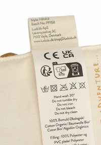 Cotton label with care instructions, featuring icons for washing and recycling. Text indicates material composition and brand details.