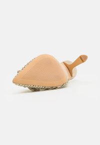 Scarpa piatta con punta affusolata, suola in gomma naturale, superficie texturizzata, dettagli in oro intrecciati e materiale superiore beige.