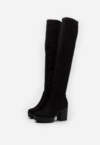 Botas negras por encima de la rodilla hechas de ante sintético, con un tacón grueso y una suela texturizada para mayor agarre. Diseño elegante y ajustado sin herrajes visibles.