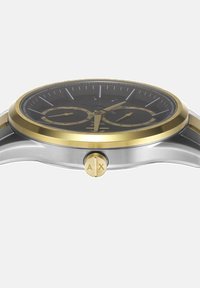 Ura iz nerjavnega jekla z črnim številčnicom, zlatimi poudarki, funkcijami kronografa in zlatim krono. Okrogla ohišje z gladko površino.