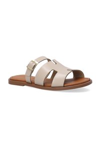 Tan og beige læder slide-sandal med tre brede stropper, udskæringer og en guld spænde accent på siden. Flad gummisål.