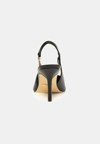 Black high-heeled shoe with a pointed toe and adjustable ankle strap. Smooth leather material and a slim stiletto heel. Gold-tone hardware accent.