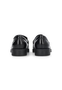 Scarpe in pelle nera con una finitura lucida, tacco basso e punta arrotondata; presentano cuciture sottili e una texture liscia.