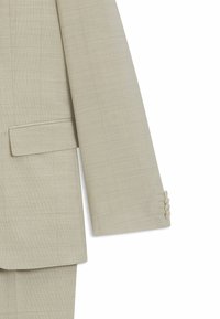Beige skräddarsydd kavaj med en strukturerad tyg, notchad slag och detaljer med fyra knappar på ärmarna. Strukturerad design med en bröstficka.