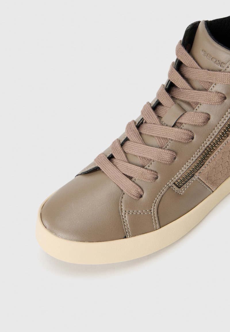 Beige leren hoge schoen met een textuur zijpaneel, platte veters en een crèmekleurige zool. Bevat subtiele stiksels en een ritsdetail.