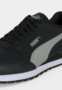 Черна и сива маратонка Puma с черни връзки, бяла междинна подметка и текстурирана черна подметка, с лого на Puma на страничната част и езика.