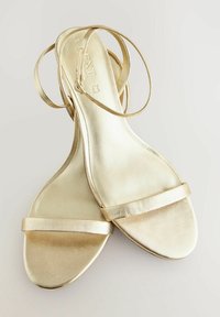 Gouden platte sandalen met dunne metalen banden en een gladde, glanzende oppervlakte. Beschikt over een minimalistisch ontwerp en open teenstijl.