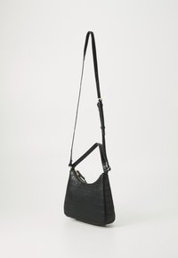 Borsa a tracolla in pelle nera con effetto coccodrillo, dotata di tracolla regolabile, chiusura con zip e texture liscia; forma curva e dettagli hardware minimi.