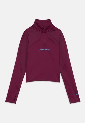 Langarmige bordeauxrode Nike Pro pullover met een kwart ritssluiting, duimopeningen op de manchetten en blauwe logotekst en swoosh op de voorkant en mouw.