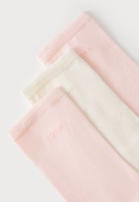 Três pares de meias: duas rosas claras e uma branca. Feitas de um tecido macio com punhos canelados. Logo discreto nas meias rosas.
