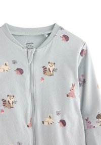 Tutina in cotone blu con zip frontale, decorata con motivi di animali e funghi nei colori pastello, adatta per neonati di età compresa tra i 4 e i 6 mesi.