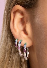 Boucles d'oreilles en argent en forme de créoles mettant en valeur trois bandes entrelacées, ornées de pierres chatoyantes multicolores, créant un effet texturé et scintillant.