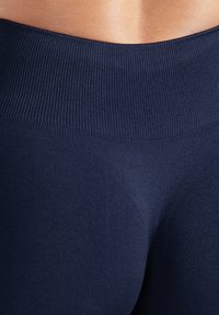 Leggings a vita alta blu navy con texture a costine e design seamless, caratterizzati da una finitura liscia e una silhouette aderente.