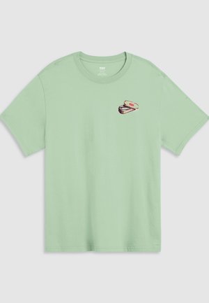 T-shirt vert clair à manches courtes avec un petit motif graphique d'une boîte de pastilles à la menthe ouverte, étiquetée "Levi's", sur la poitrine gauche.