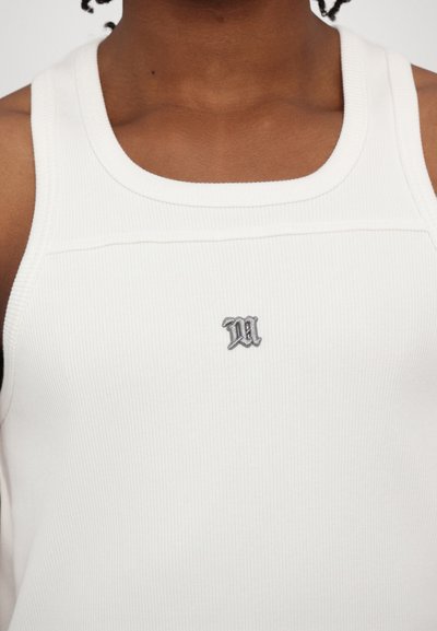 Hvid ribbet tanktop med rund halsudskæring og et lille gråt broderet bogstav "M" på midten foran.