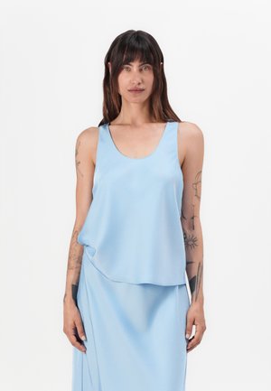 Haut sans manches bleu clair en tissu lisse et fluide. Il présente un col rond et un ourlet asymétrique décontracté.